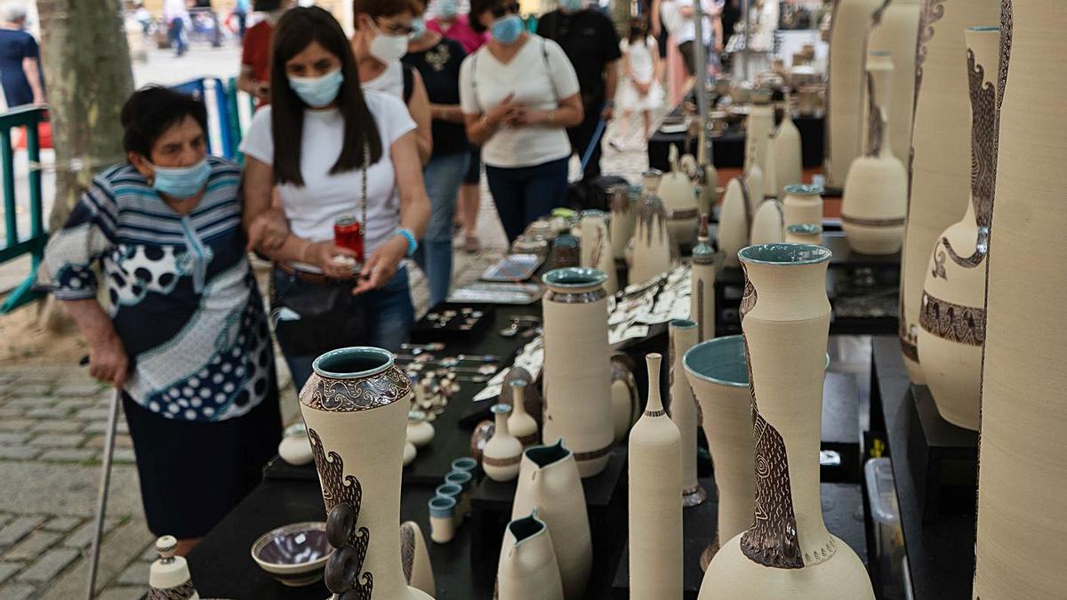 Ciudadanos visitan la Feria de la Cerámica guardando distancia de seguridad.