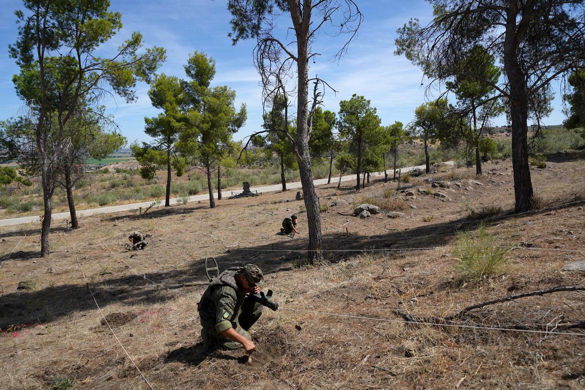 Un soldado ucraniano ensaya en un pinar de la Academia de Infantería de Toledo los métodos que ha aprendido para localizar y señalar minas.