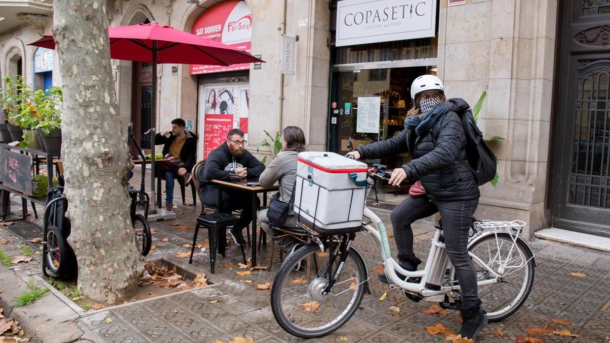 Una de las integrantes del servicio de mensajería ético de Les Mercedes recoge un pedido en el restaurante Copasetic