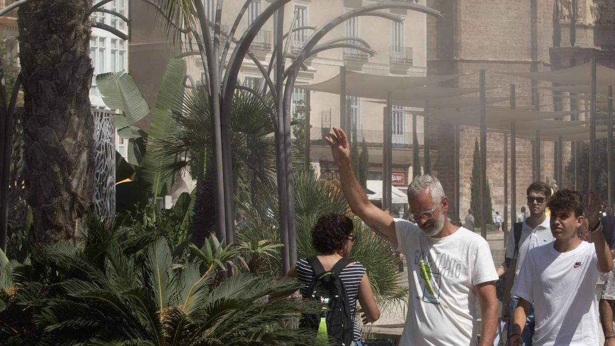 Un hombre pasa por los vaporizadores de la plaza de la Reina de València durante una ola de calor el verano pasado.