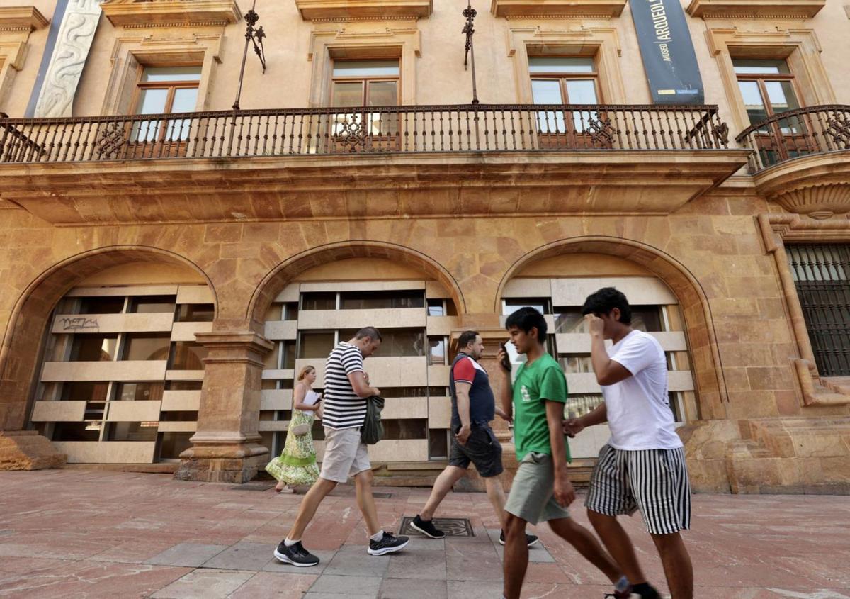 Los viandantes pasan ante la fachada del Museo Arqueológico de Asturias, en la calle San Vicente. | Irma Collín