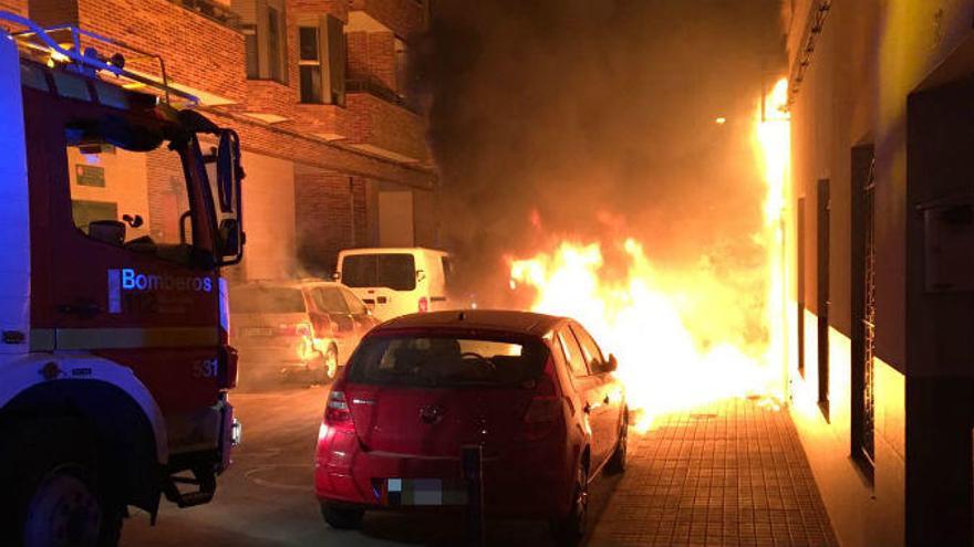 Daños en una fachada y tres vehículos por la quema de contenedores en Crevillent