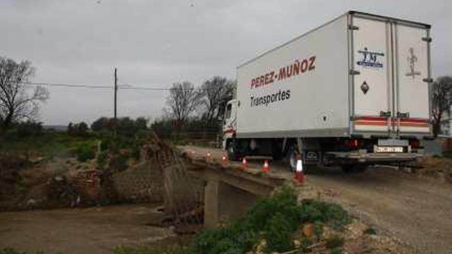 Un camión pasa con peligro sobre la maltrecha infraestructura.