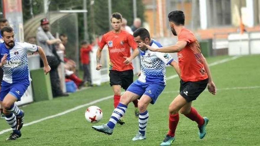 Villanueva, con el balón, rodeado por dos jugadores del Colunga.