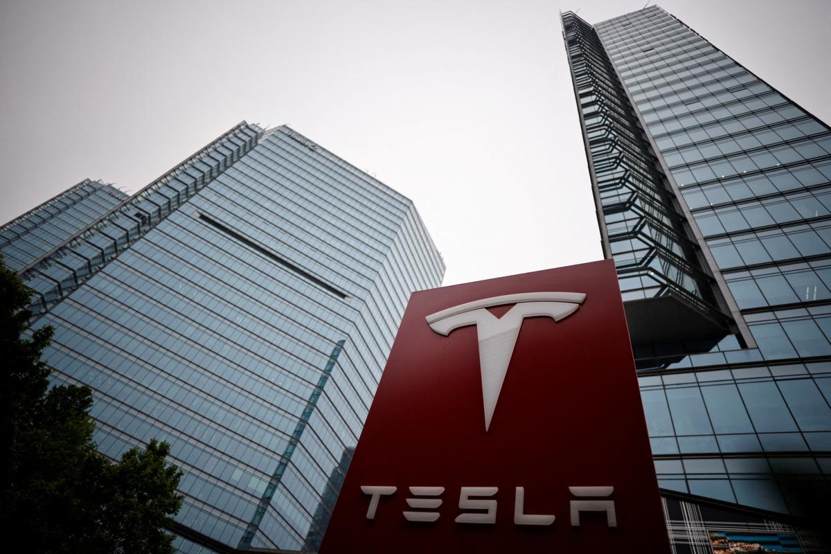 FILE PHOTO: A Tesla logo is seen outside a showroom of the carmaker in Beijing