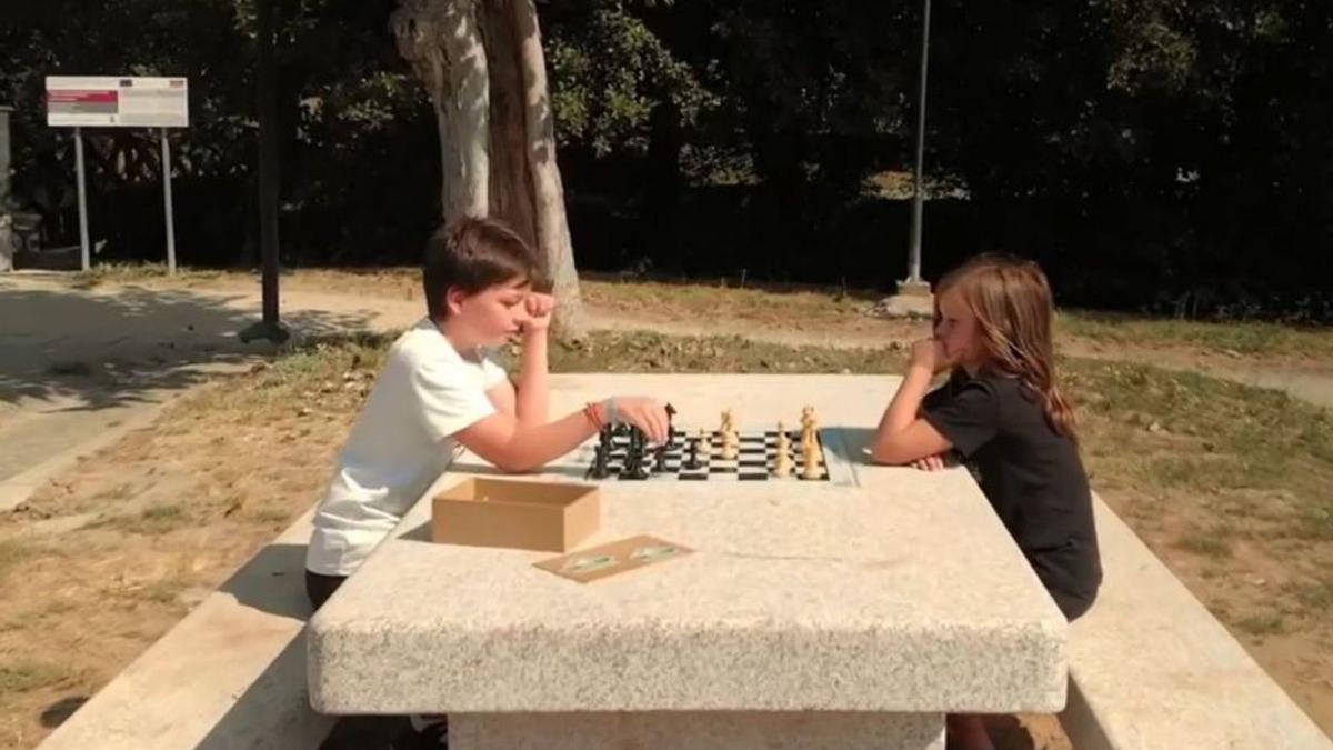 Dos niños en una de las mesas de ajedrez de Gondomar.