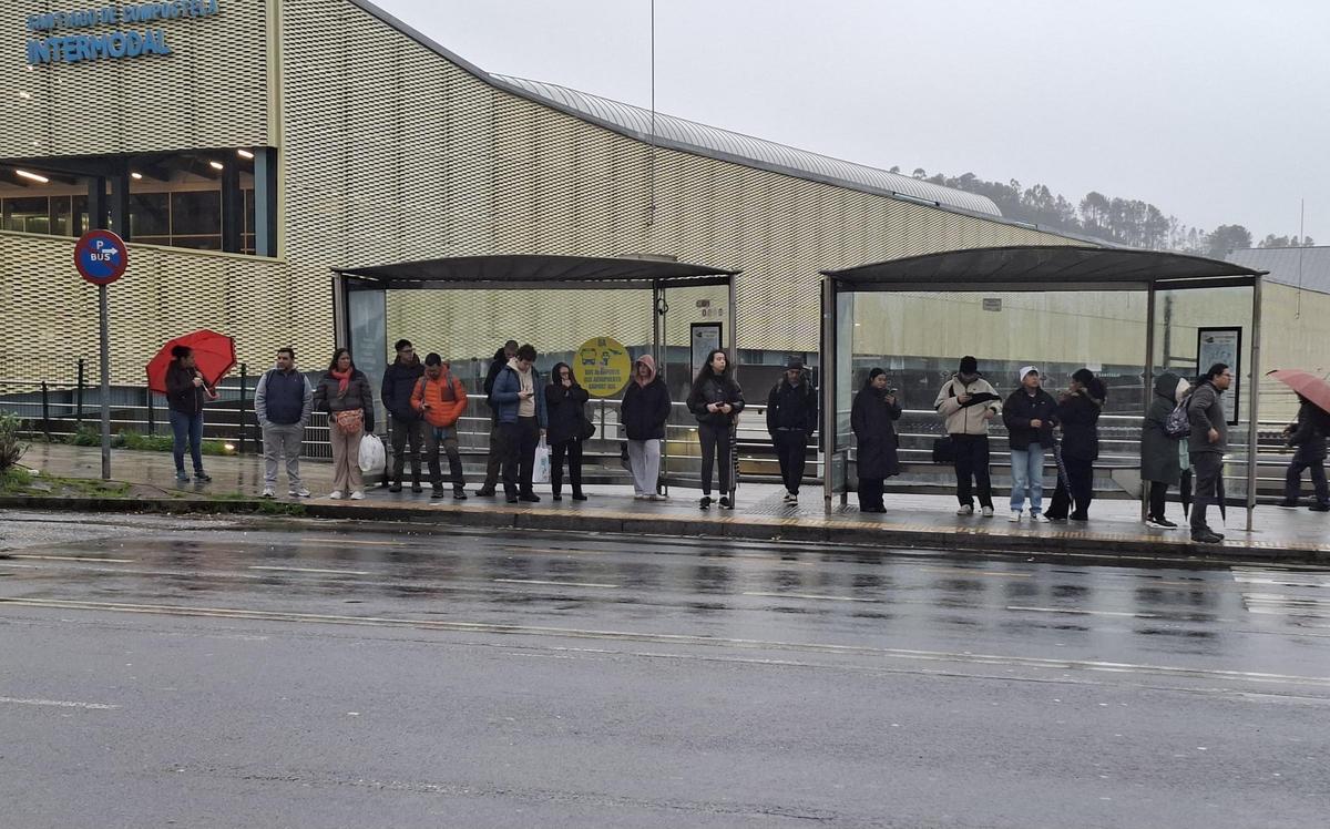 Compostelanos esperan un autobus en la salida de la estación Intermodal en esta nueva jornada de huelga