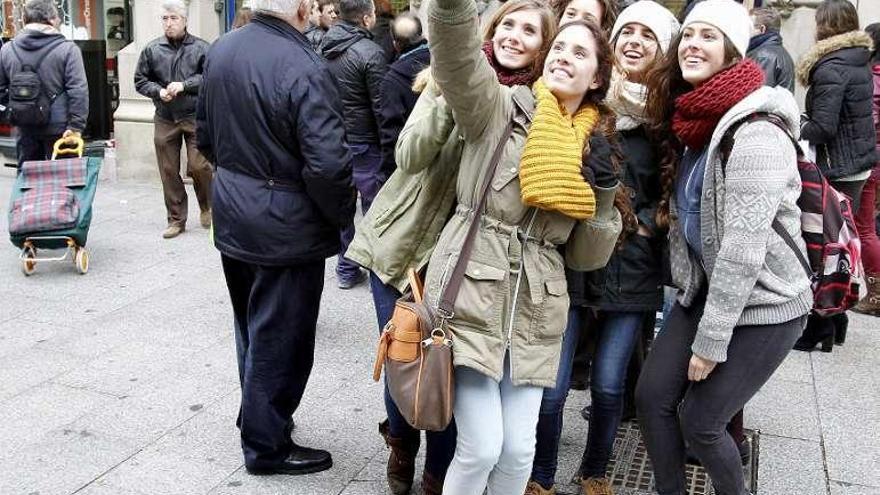 Varias jóvenes se hacen un selfi en plena calle.