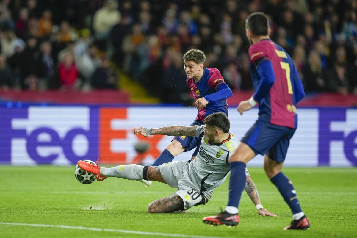 BARCELONA, 11/03/2025.- El centrocampista del FC Barcelona Marc Casadó (i) dispara a puerta defendido por el argentino Nicolás Otamendi, del Benfica, durante el partido de vuelta de octavos de final de la Liga de Campeones entre el Barcelona y el Benfica, este martes en el Estadi Olímpic Lluís Companys en Barcelona. EFE/ Alejandro García