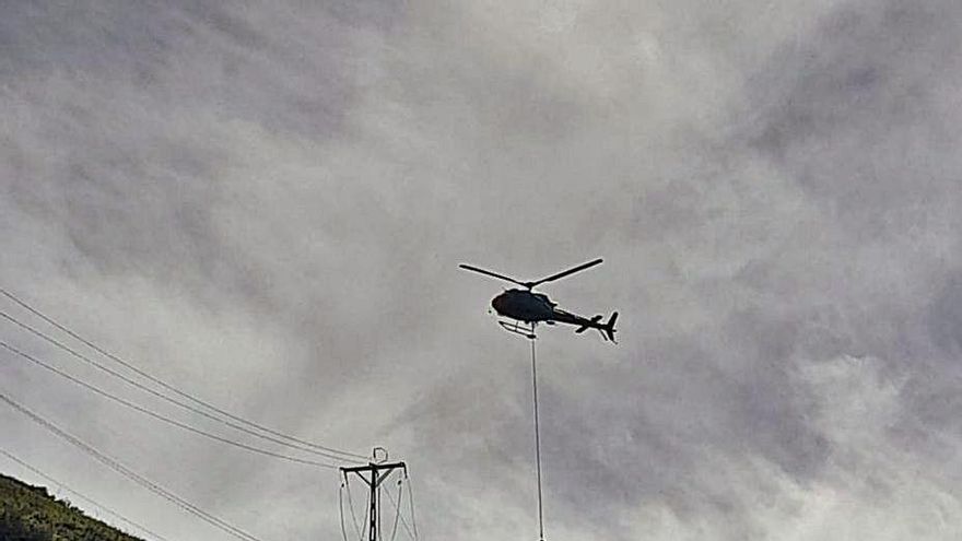 El helicóptero coloca una de las nuevas torres.