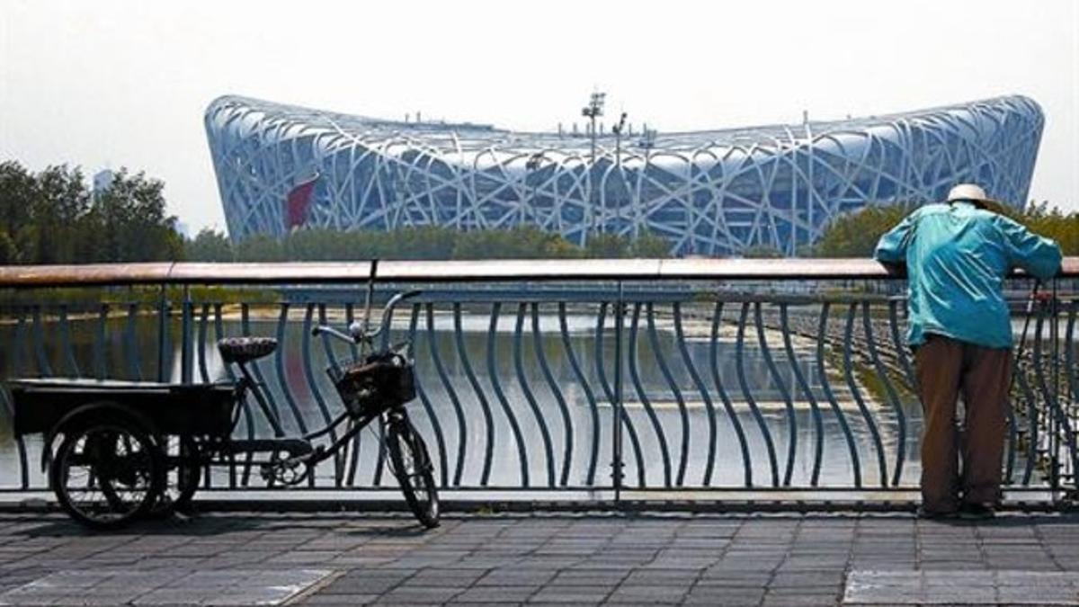 El Nido de Pájaro 8 Un ciudadano pesca desde un puente frente al Estadio Olímpico de Pekín.