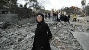 Residentes del pueblo de Aita al -Shaab, en el sur del Líbano, pasan junto a un edificio destruido por bombardeos israelíes.