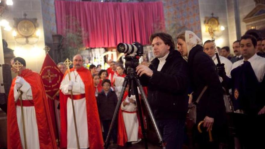 La directora del reportaje cultural de la televisión rusa, María Guseva, junto a uno de los cámaras de su equipo, el Jueves Santo, durante la grabación del rito del indulto en el interior de la iglesia de San Juan el Real. | miki lópez