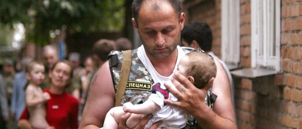 Un policía ruso sostiene a un bebé ileso tras el ataque checheno a una escuela de Beslán (Rusia), el 2 de septiembre de 2002