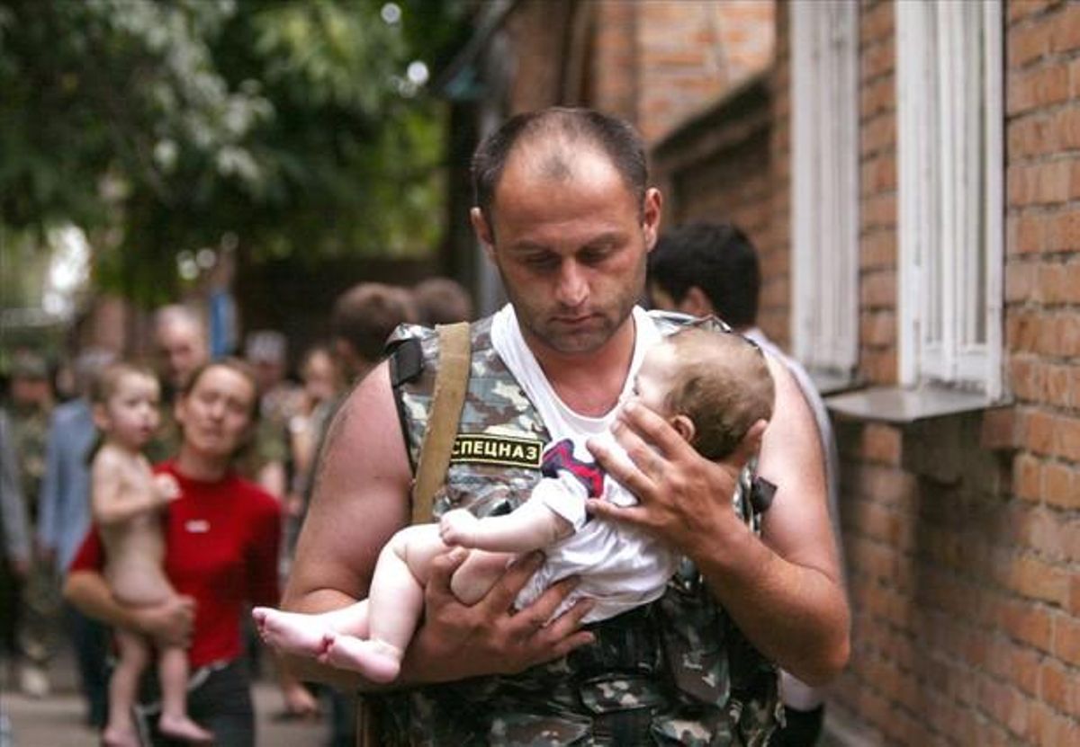 Un policía ruso sostiene a un bebé ileso tras el ataque checheno a una escuela de Beslán (Rusia), el 2 de septiembre de 2002