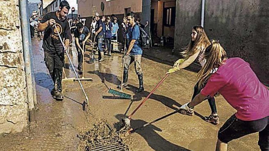 Un grupo de voluntarios limpiando las calles de Sant Llorenç.