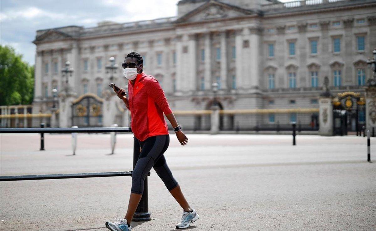 Un ciudadano pasa frente al palacio de Buckingham.