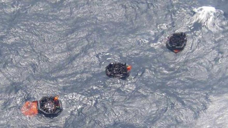 Vista aérea de varias personas a bordo de botes salvavidas después de que un barco con unos 350 pasajeros naufragara.