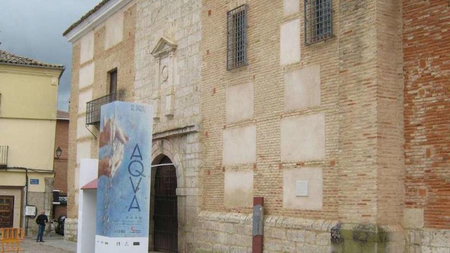 Un vecino observa el soporte publicitario de Aqva instalado en la entrada del Santo Sepulcro. Foto