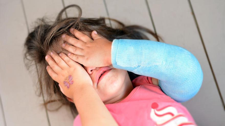 Una niña se cubre la cara mientras llora.