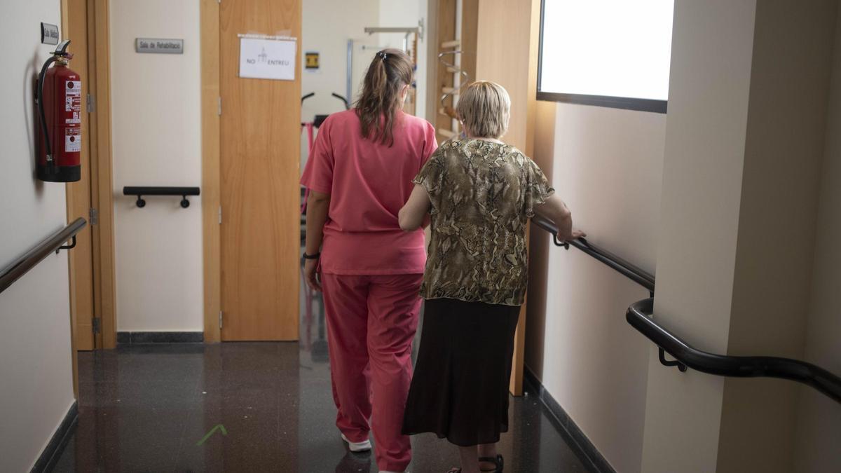 Una mujer dependiente acompañada por una profesional sanitaria en un centro de Aielo de Malferit.