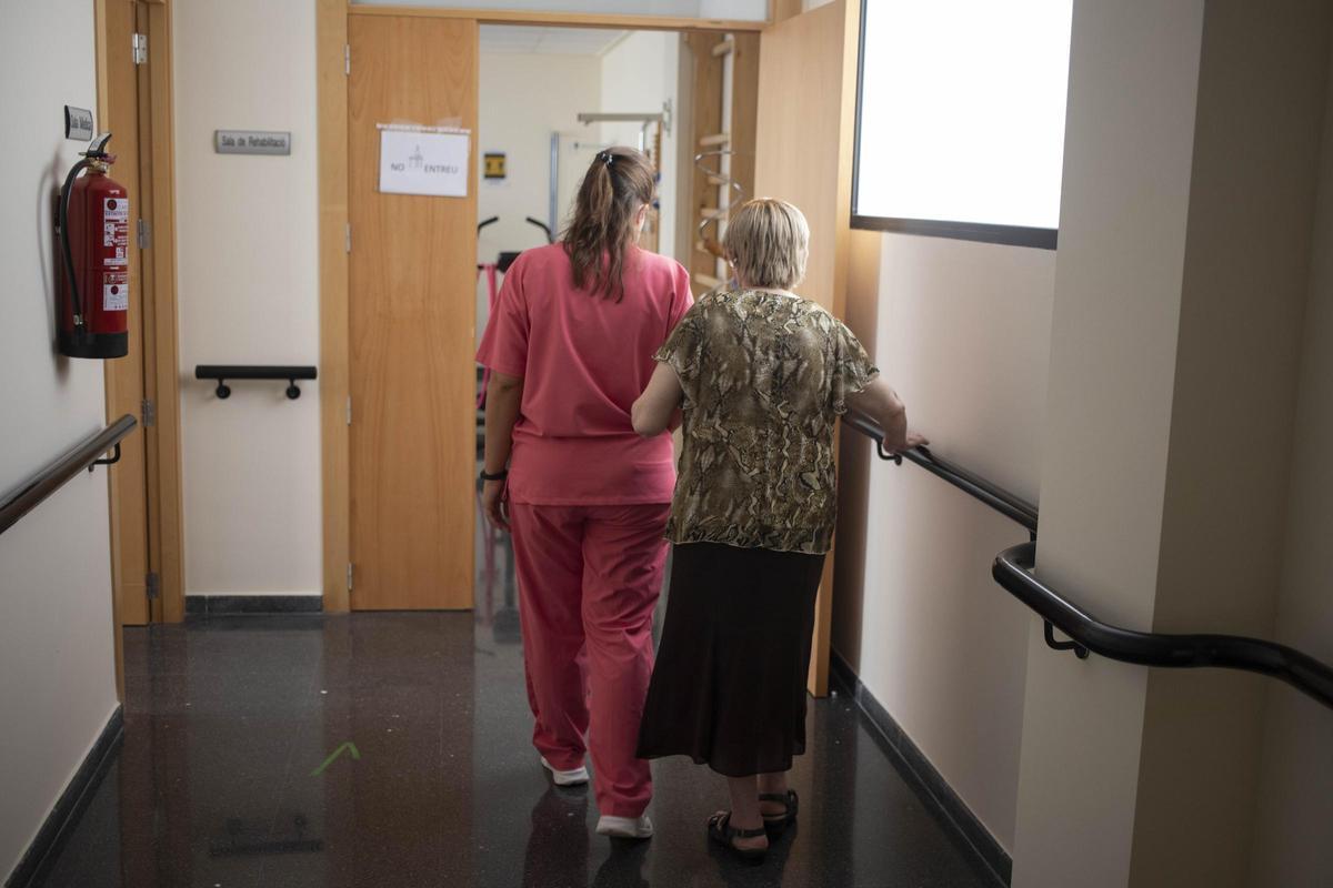 Una mujer dependiente acompañada por una profesional sanitaria en un centro de Aielo de Malferit.