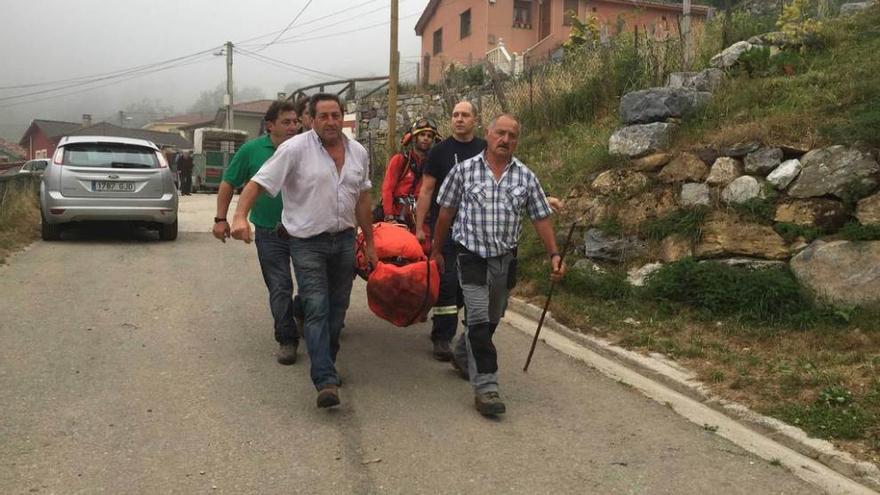 Vecinos y efectivos de Bomberos de Asturias, en Tuiza de Arriba, portando la camilla con el cuerpo de José Manuel Gutiérrez (en el recuadro).