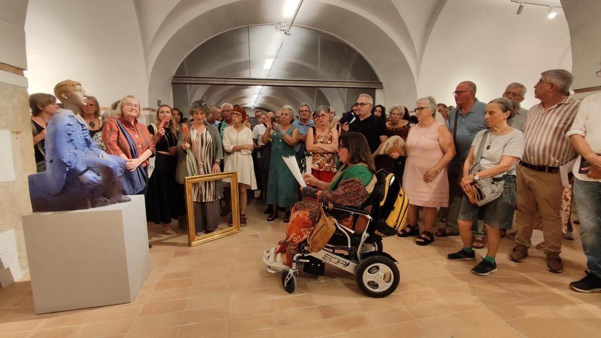 La comissària de l'exposició, Lola Ventós, parlant de la peça d'un dels artistes participants, Eudald de Juana.