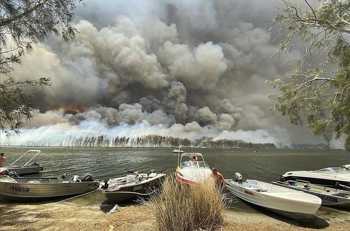 Barcos en la orilla del lago Conjola, cuyos alrededores están amenazados por el fuego.