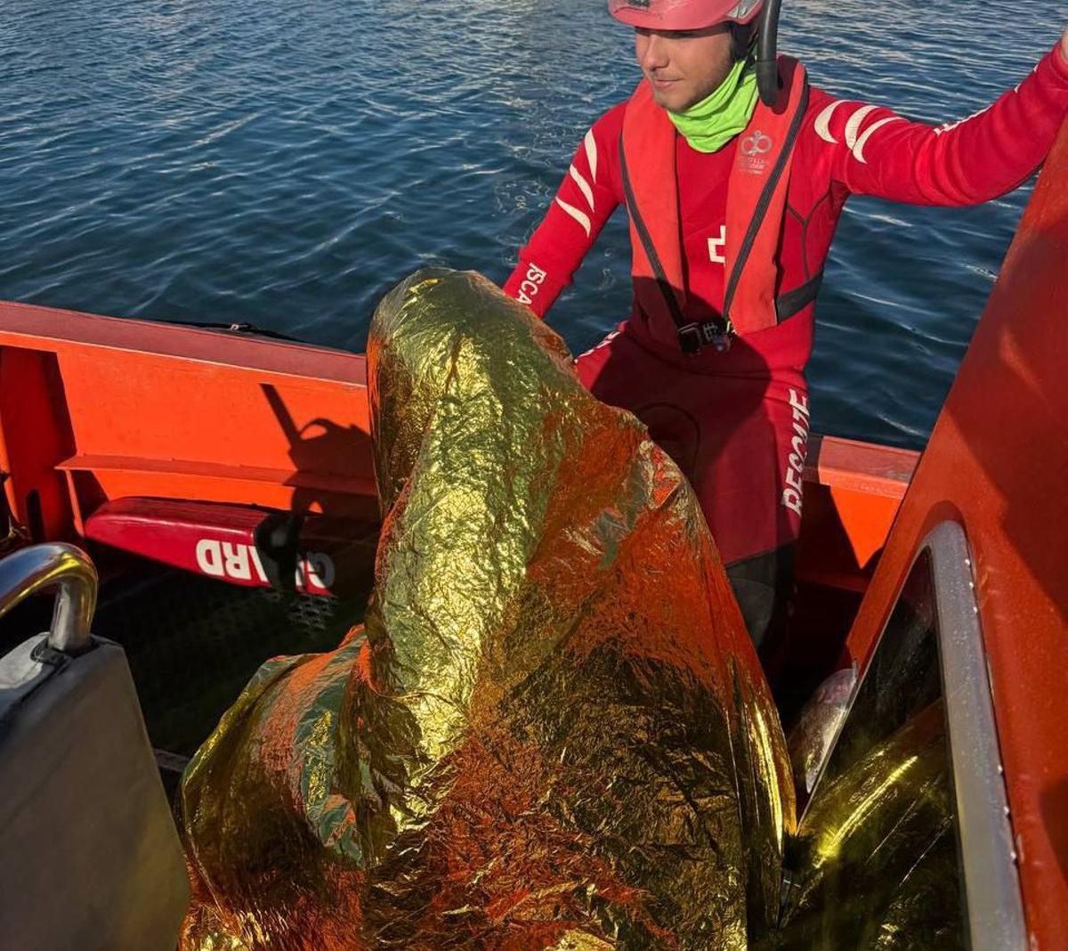 Un miembro de Cruz Roja con el hombre de 37 años rescatado.