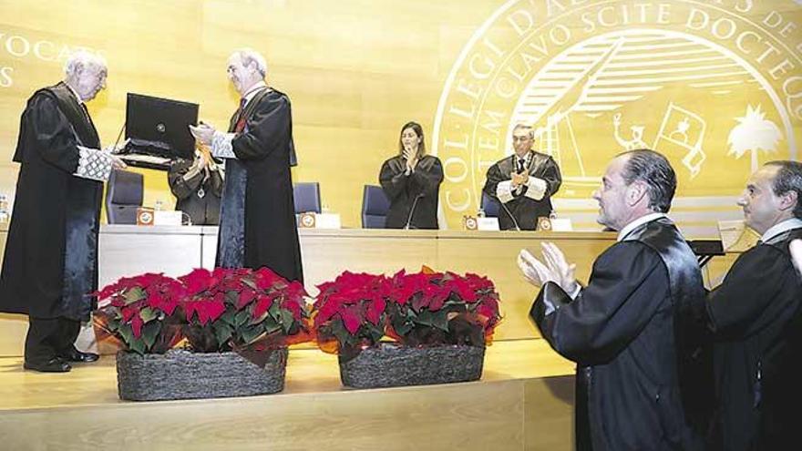 Perera recibe el premio de manos de Aleñar, decano del Colegio de Abogados, con su hijo entre el público.