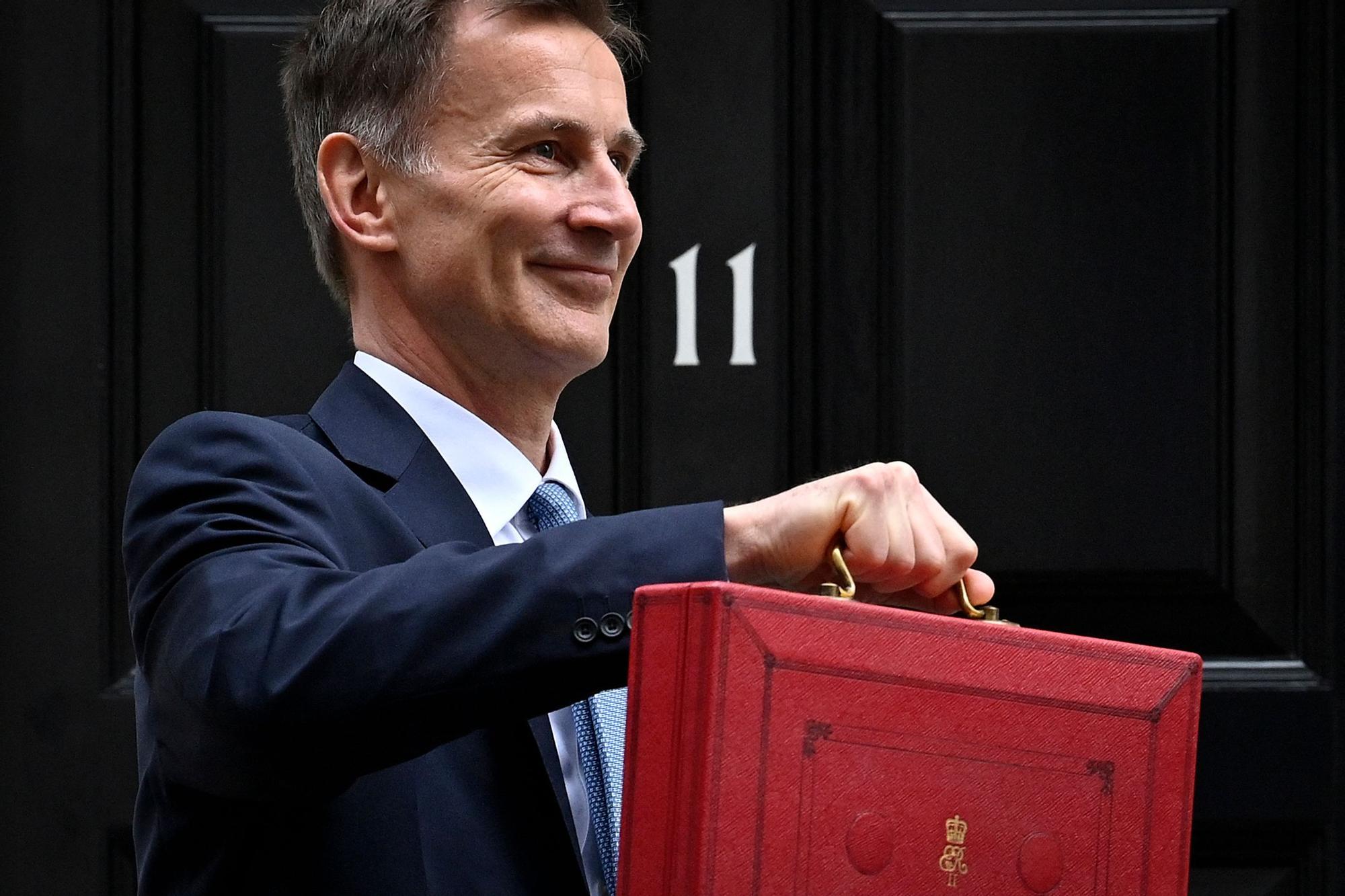 El ministro británico de Finanzas, Jeremy Hunt, posa con la carpeta roja del presupuesto, este miércoles en Londres.