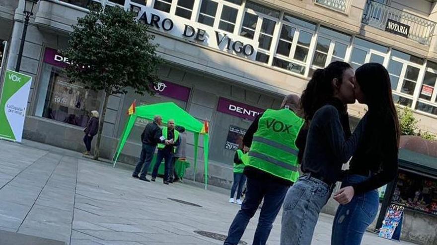 Imagen del beso delante del puesto de Vox en Vilagarcía. // Faro