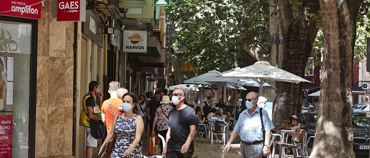 Transeúntes caminan ante una terraza en la Albereda Jaume I de Xàtiva | PERALES IBORRA