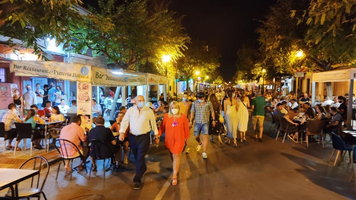 Decenas de personas pasean por el medio de la calle Santo Tomás de Benicàssim mientras los clientes de los bares consumen en las ampliadas terradas.