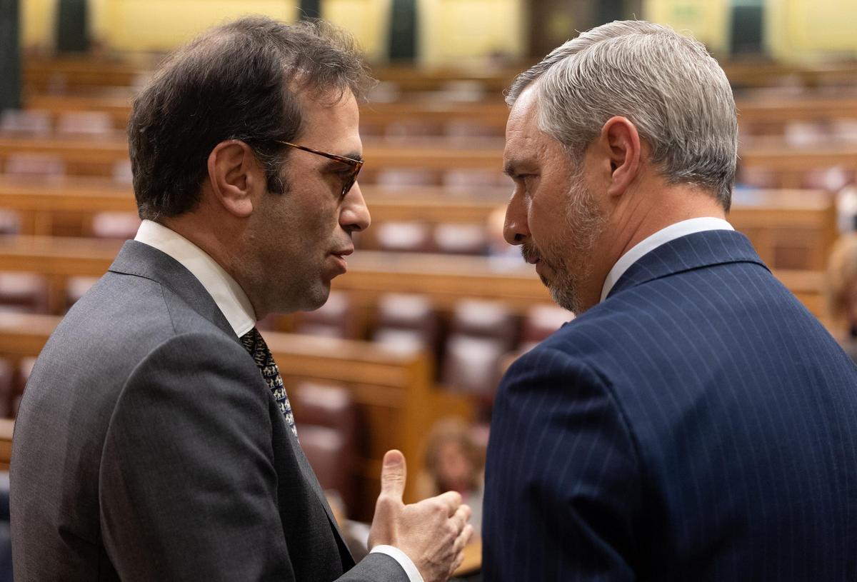 El ministro de Economía, Carlos Cuerpo, conversa con el responsable de Economía del PP, Juan Bravo, en el Congreso de los Diputados el pasado 9 de abril.