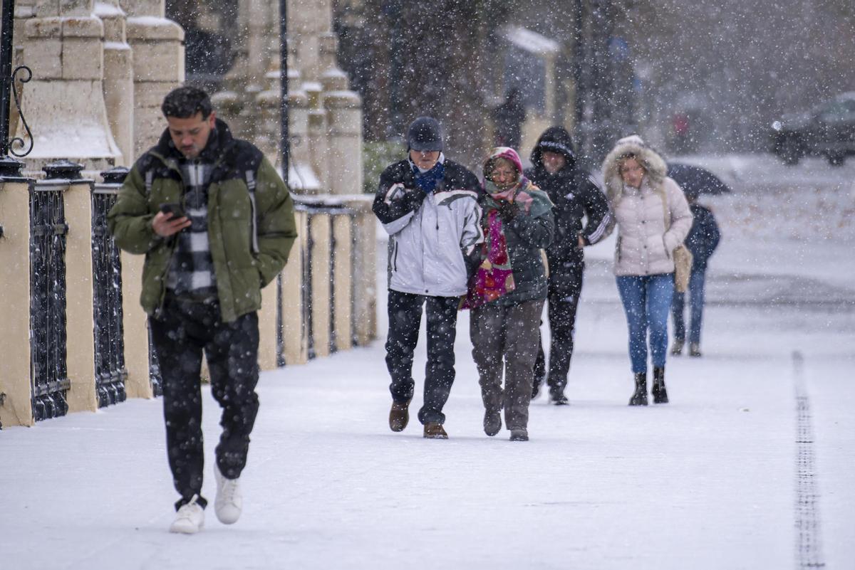 Varias personas caminan por Teruel bajo la nevada a principios de enero