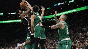 Irving se queda sin opción de tiro, defendido por dos jugadores de los Celtics