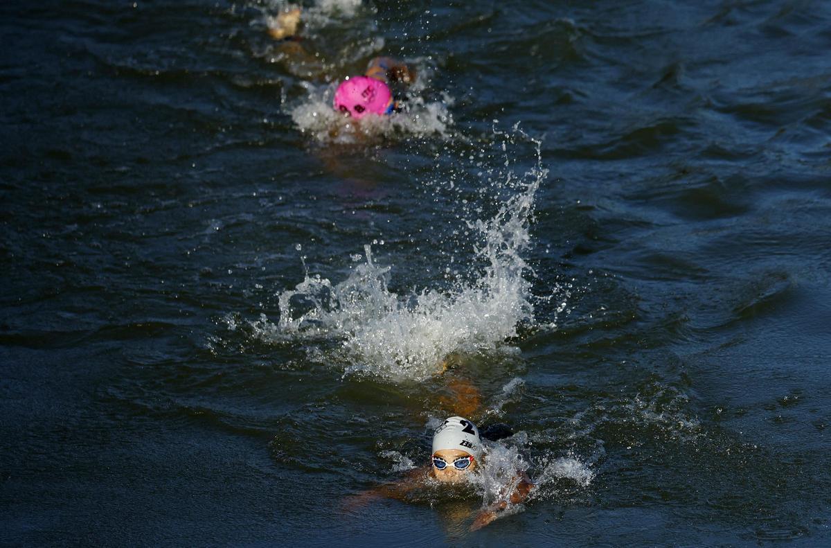 Atletas nadando en el río Sena durante la prueba mixta de triatlón en los Juegos de Paris 2024