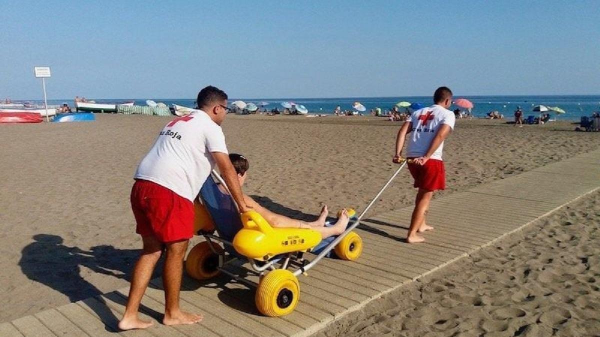 Dos voluntarios de Cruz Roja ayudan a una mujer a darse un baño.