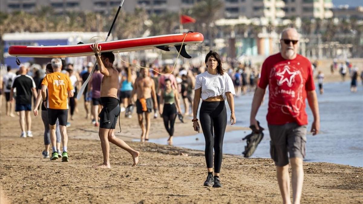 Ciudadanos pasean por la playa de la Malvarrosa, en Valencia