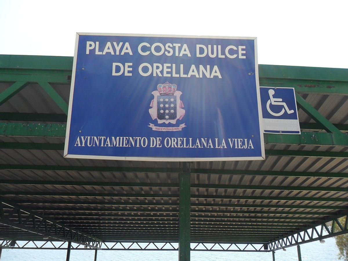 Cartel indicativo de la playa en el embalse de Orellana, con Bandera Azul en aguan interiores