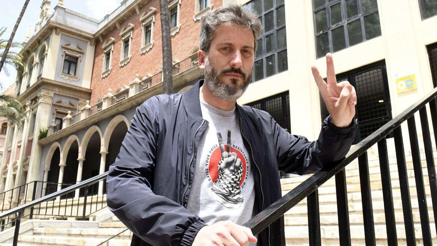 Víctor Egío hace la señal de victoria con una camiseta de apoyo al pueblo palestino.