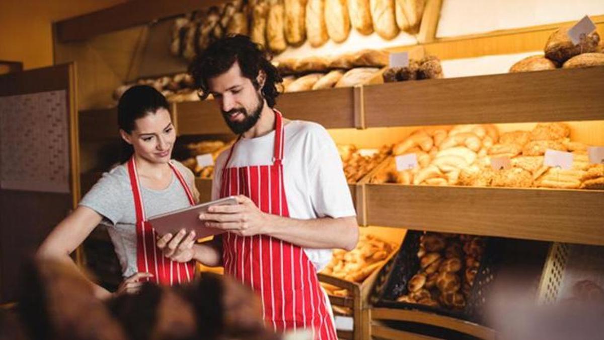 Dos profesionales atienden un establecimiento de pan y repostería. Los tiempos para trámites consumen a los autónomos.