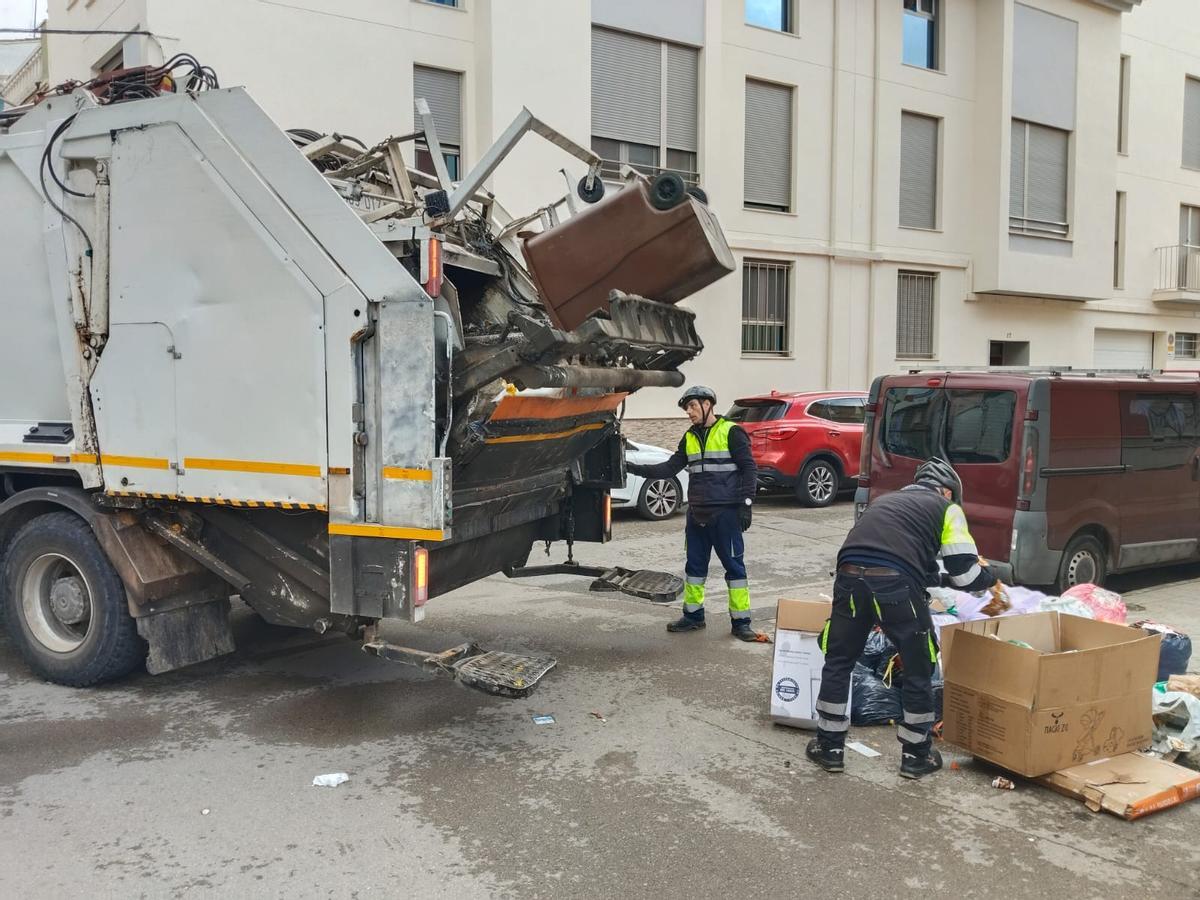 Operarios de la empresa contratada por el ayuntamiento, este jueves, retiran basura acumulada en la calle.