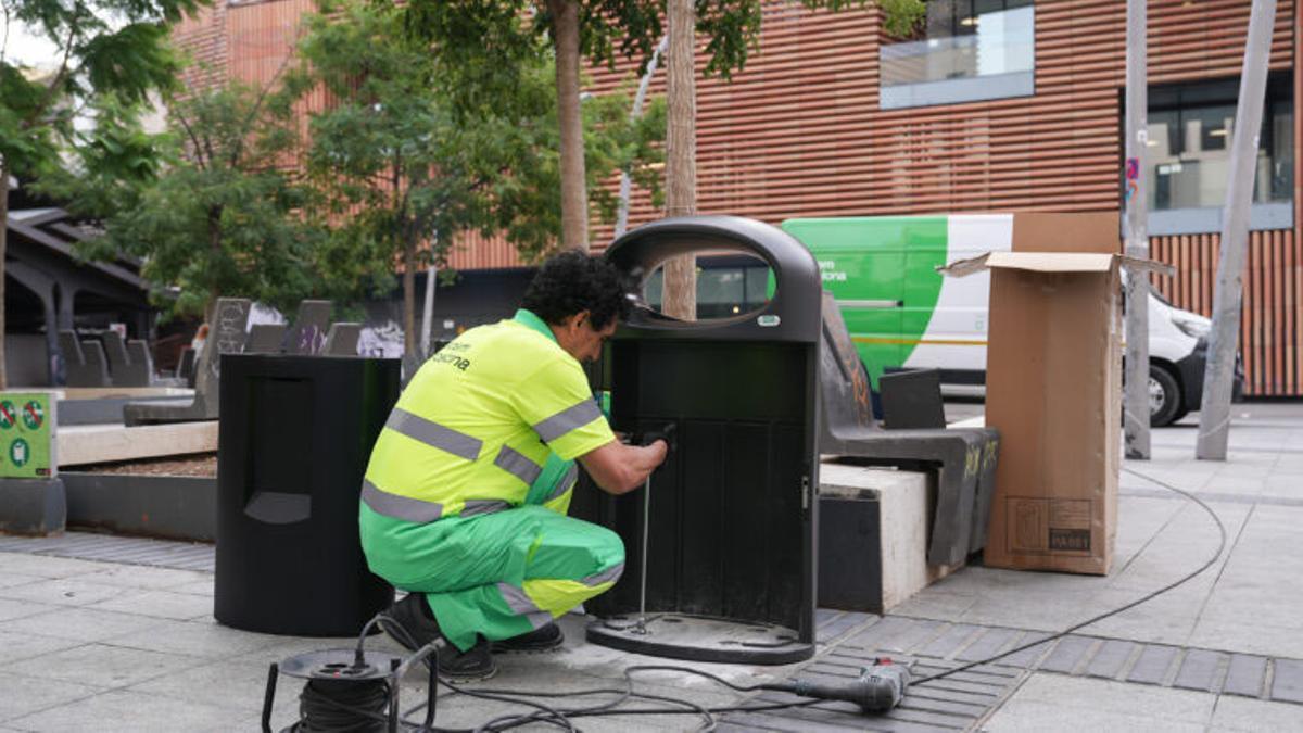 Un trabajador cambia un buzón de residuos en Barcelona