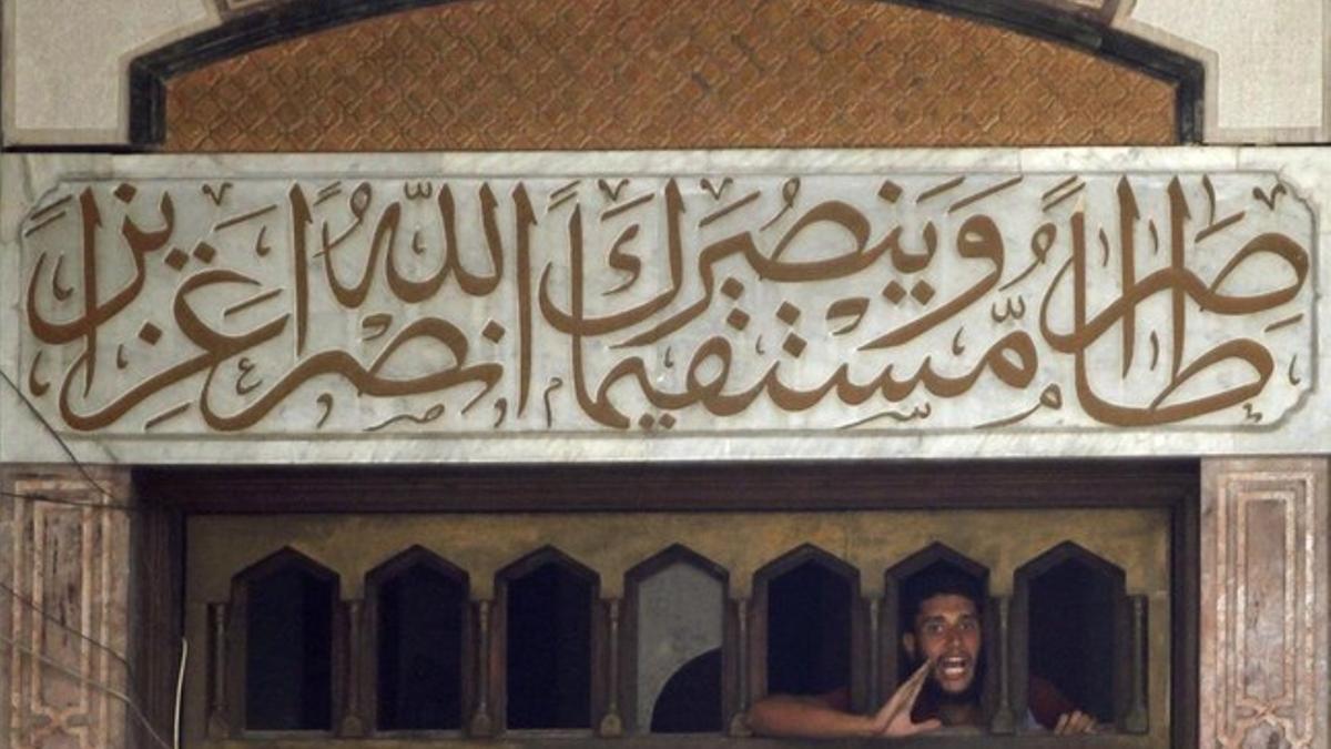 Un simpatizante de Mursi grita desde lo alto de la mezquita de Al Fath