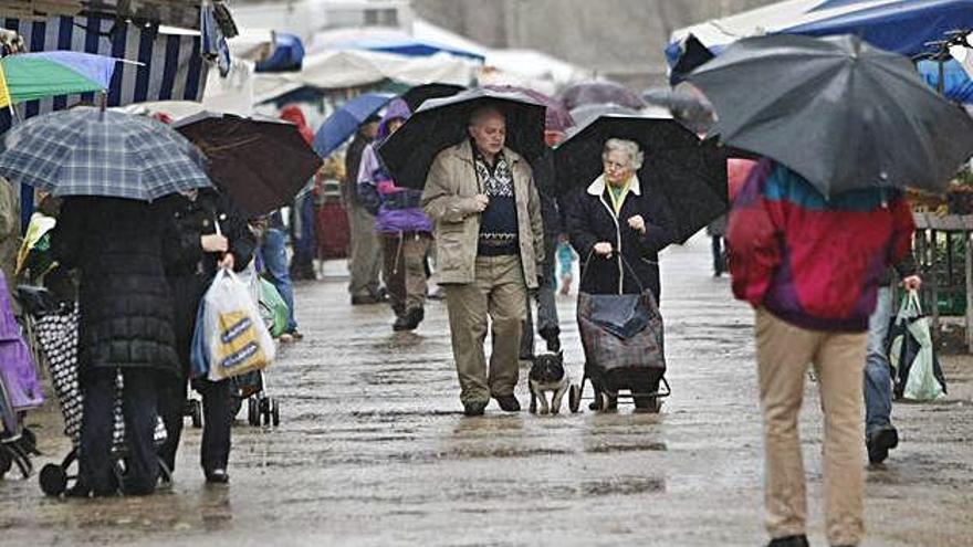 Gent amb paraigües passejant per Girona, en una imatge d&#039;arxiu.