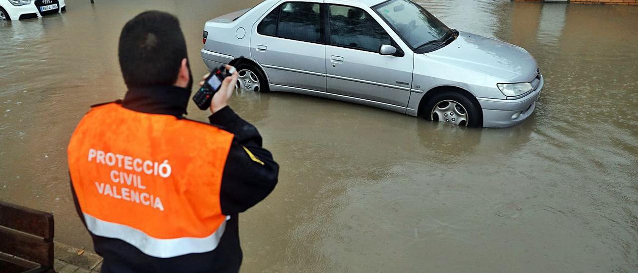 Un miembro de Protección Civil alerta por radio para que rescaten un coche.  | K.F./EFE