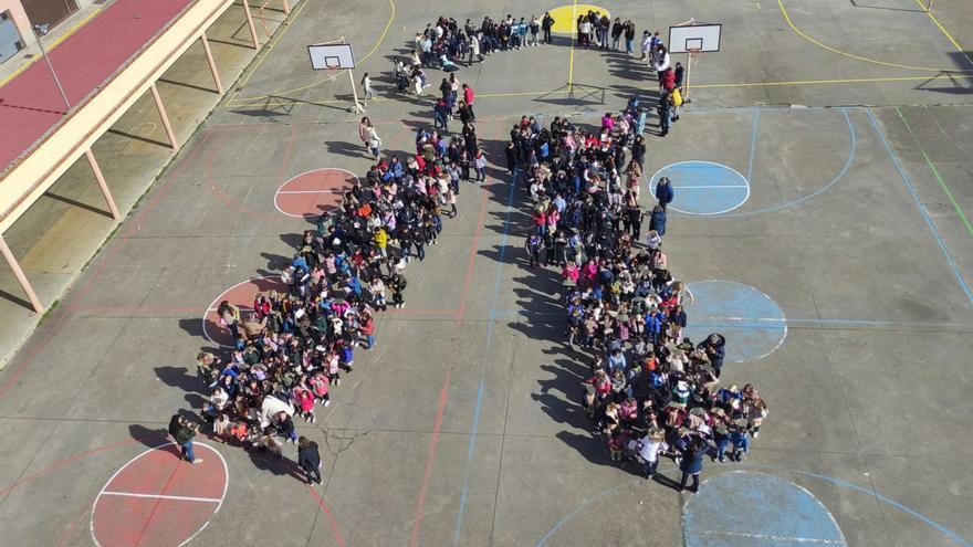 El colegio Virgen de la Vega formó un gran lazo humano en el patio. | E. P.
